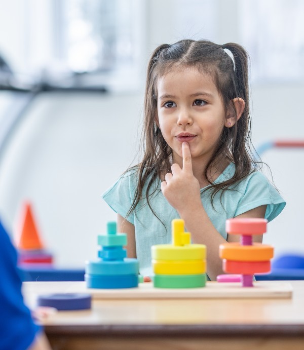 Ein junges Mädchen sitzt bei der ADHS-Diagnostik und wird spielerisch in den Ablauf eingebunden